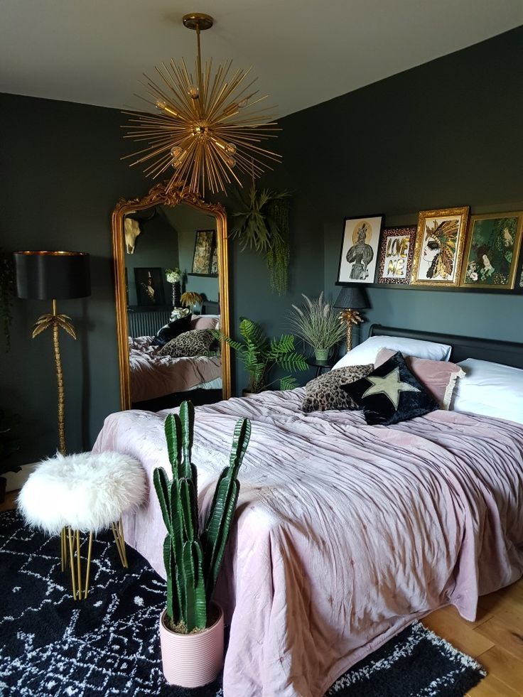 a bedroom with a bed, mirror and plants in the corner on the rugs