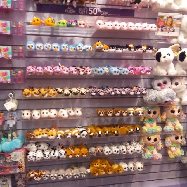 there are many stuffed animals on display in the store