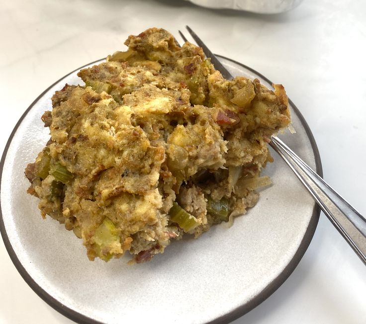 a white plate topped with food next to a fork