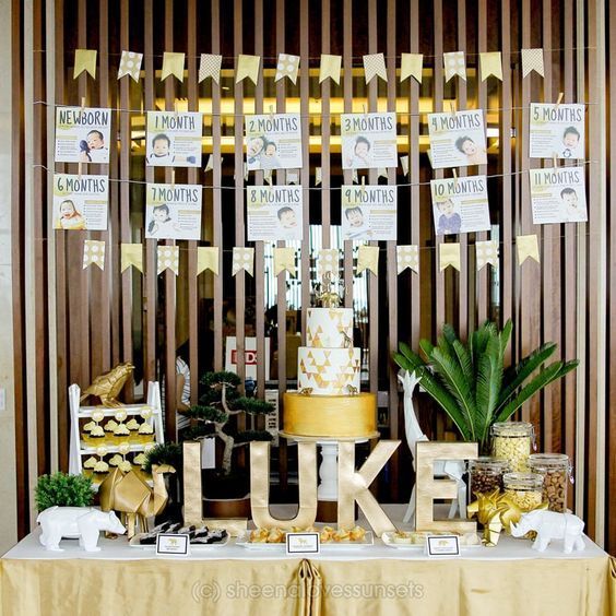 a table topped with a yellow cake and lots of gold decorations on top of it