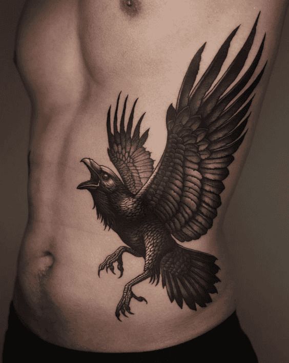 a black and white photo of a man's stomach with an eagle tattoo on it