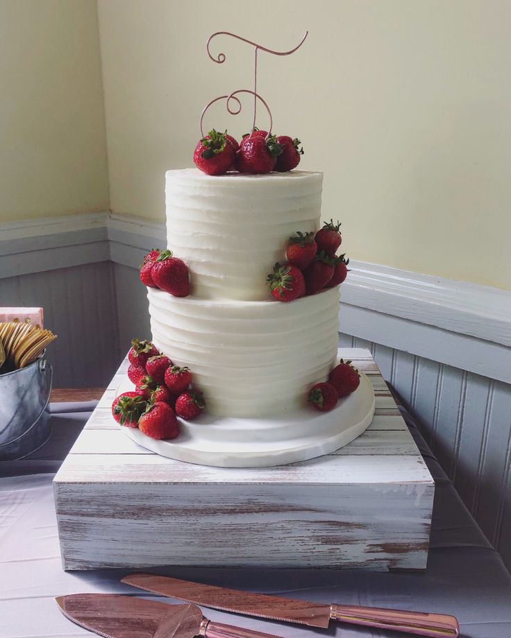 a three tiered cake with strawberries on top