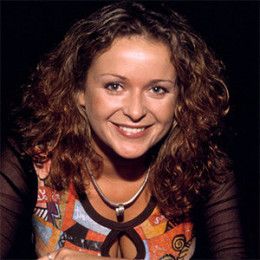 a woman with curly hair smiling at the camera