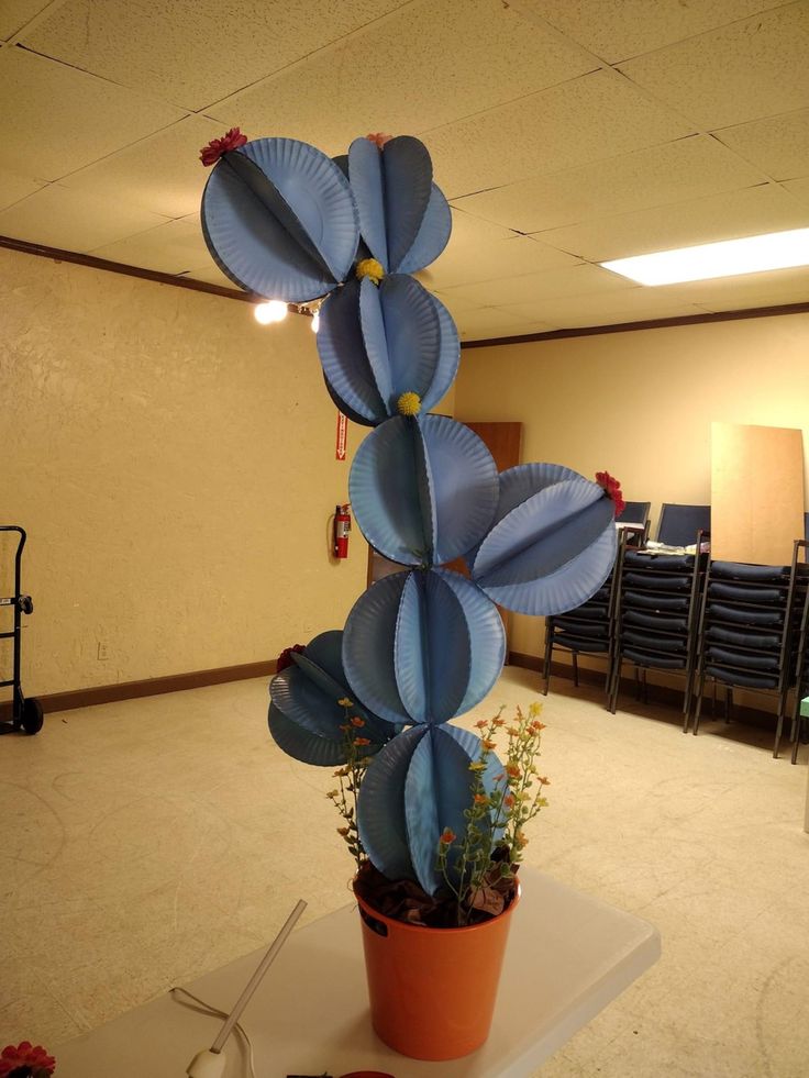 a potted plant sitting on top of a table in front of a room filled with chairs