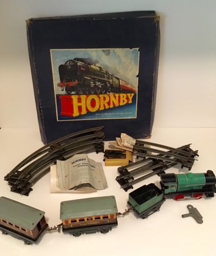 an assortment of toy trains and accessories in a box on a white table with a blue background