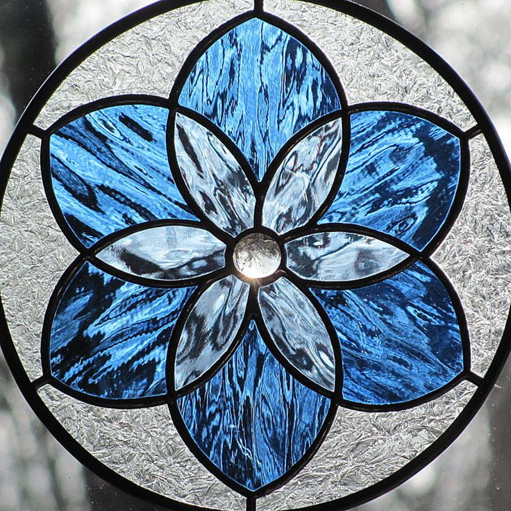 a close up of a stained glass window with a flower design on it's side