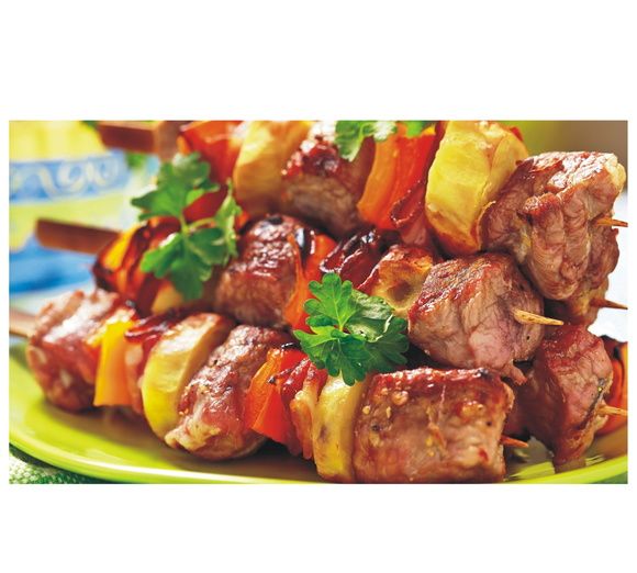 skewered meat and vegetables on a green plate