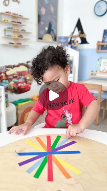 a little boy that is sitting at a table with some sort of crafting material