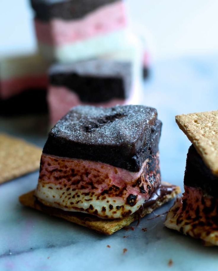 there are several desserts on the table with crackers around them and one is chocolate