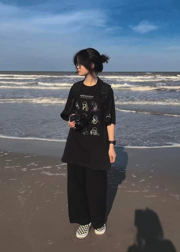 a woman standing on top of a beach next to the ocean