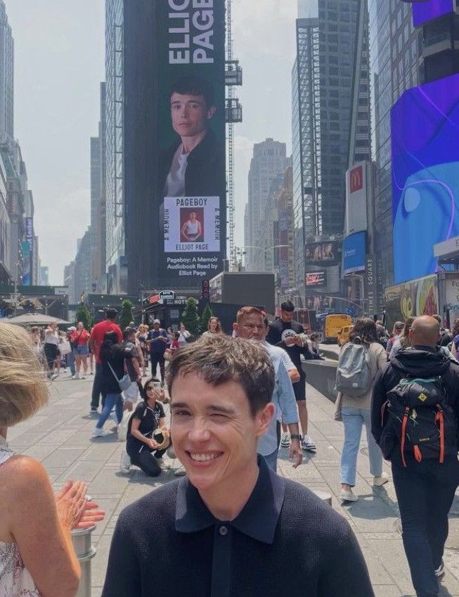 a man standing in the middle of a busy city street with people walking around him