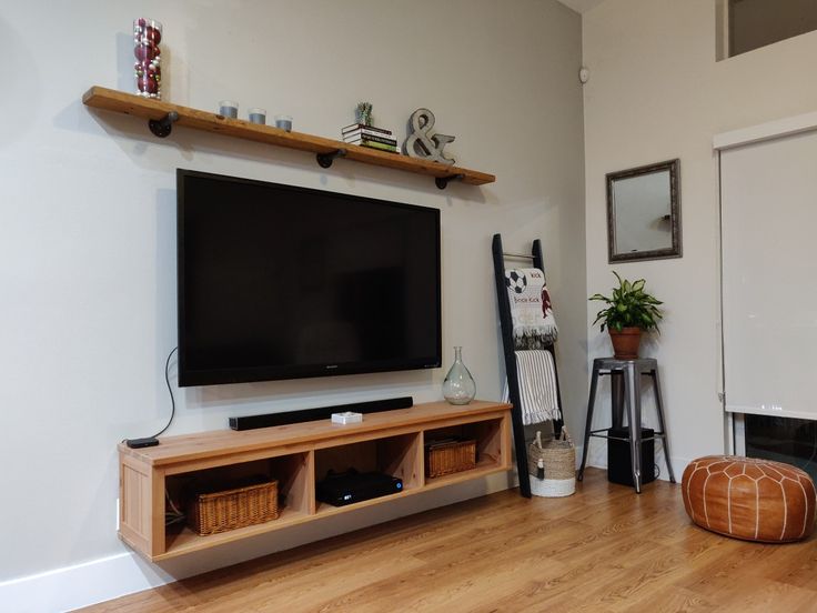 a flat screen tv sitting on top of a wooden shelf