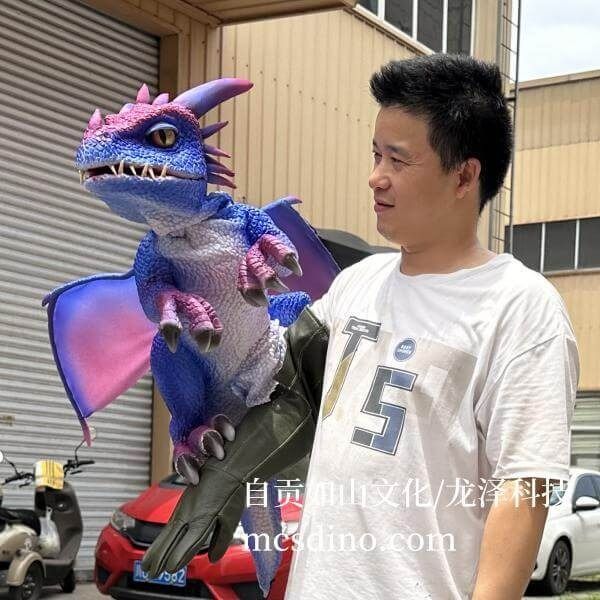 a man standing next to a toy dragon