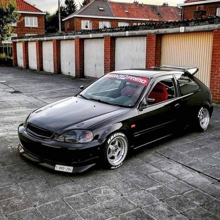 a black car parked in front of a garage