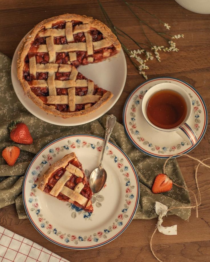 a piece of pie sitting on top of a plate next to a cup of tea