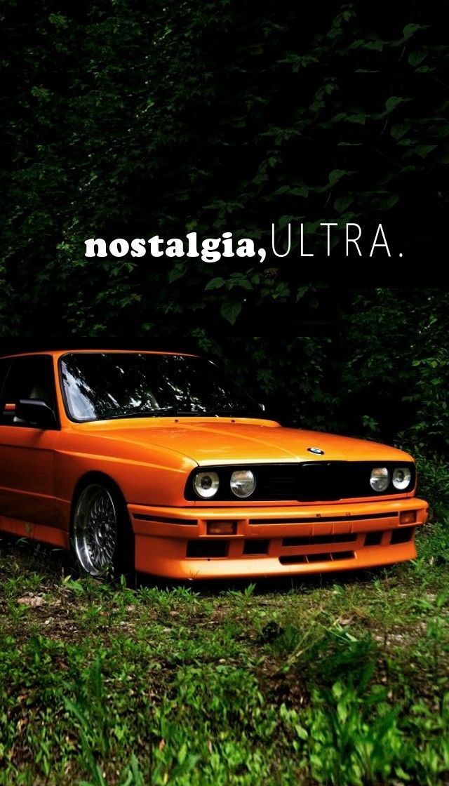 an orange car is parked in the grass near some trees and bushes with words that read nostalgica ultra