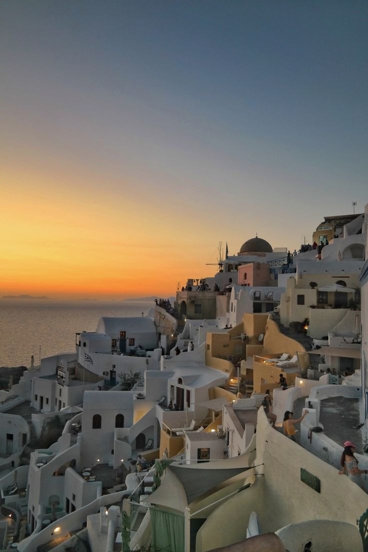 the sun is setting over some white buildings