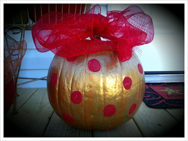 a pumpkin decorated with red and yellow polka dots