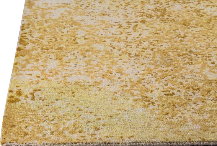 an area rug that is yellow and brown with spots on the carpet, it appears to be worn or faded