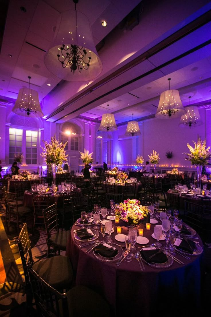 a banquet room with purple lighting and round tables