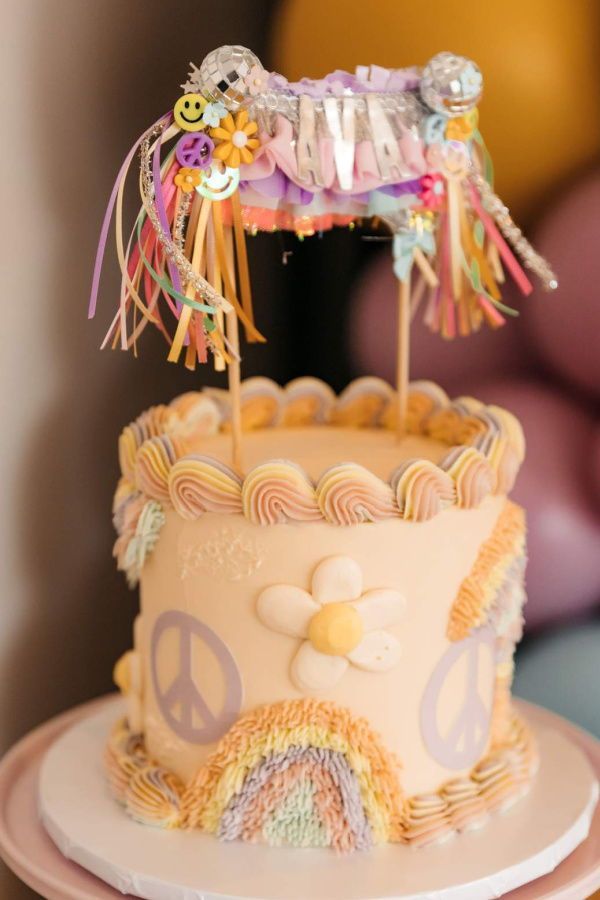 there is a cake that looks like a peace sign on the top and rainbow decorations around it