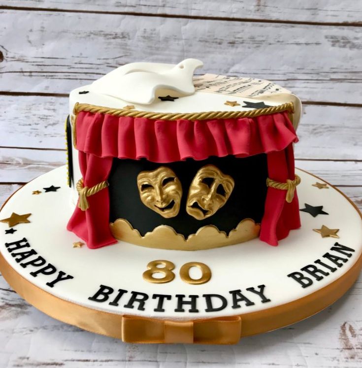 a birthday cake with two masks on top and the words happy 80th birthday written in gold