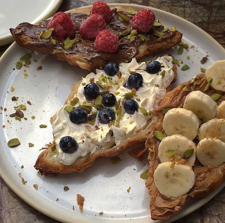 two pieces of toast with bananas and blueberries on it