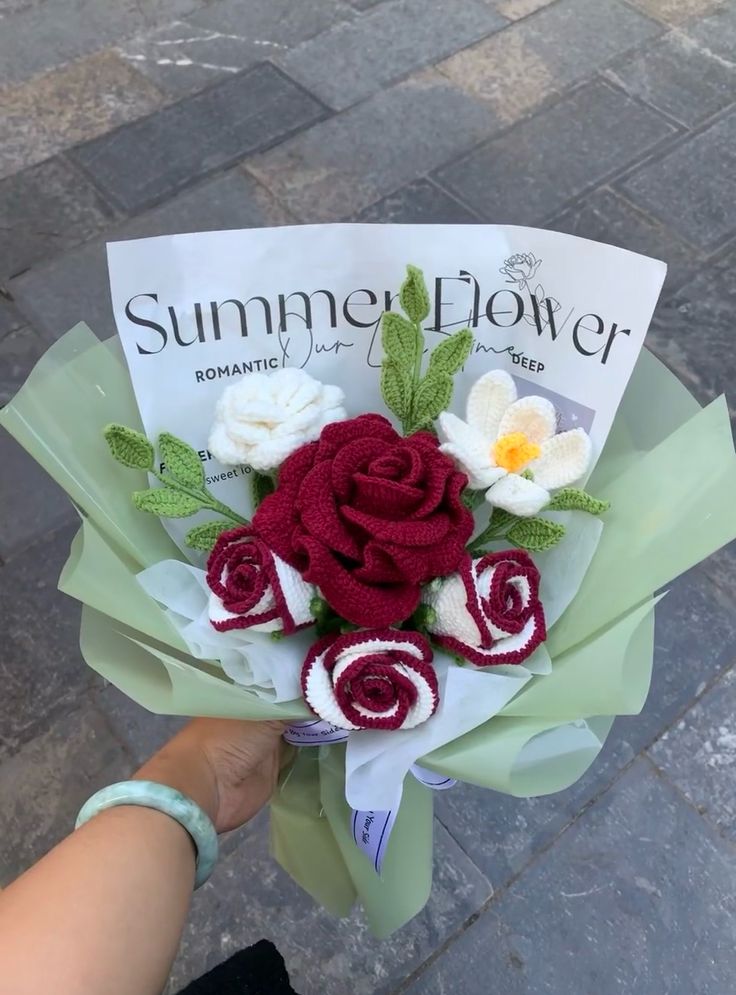 someone is holding a bouquet of flowers on the street