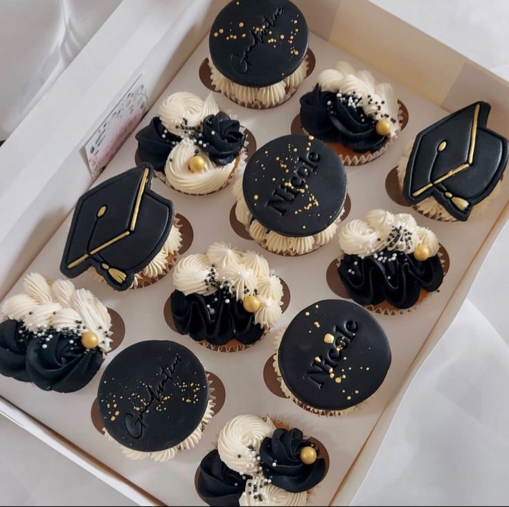 cupcakes decorated with black and white frosting in a box