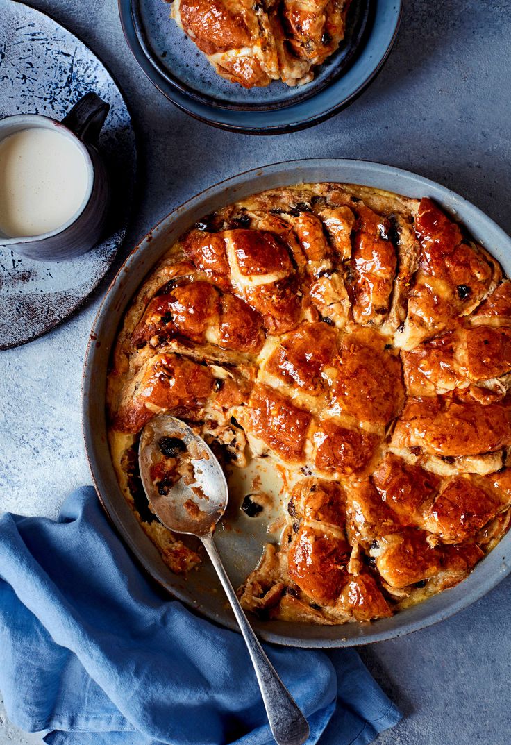 a pie sitting on top of a pan next to a cup of milk and a spoon