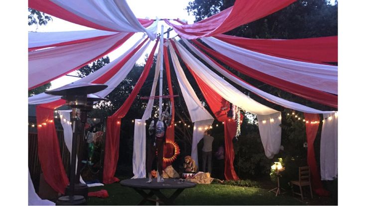 an outdoor tent decorated with red, white and black drapes