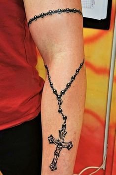 a woman with a rosary tattoo on her arm