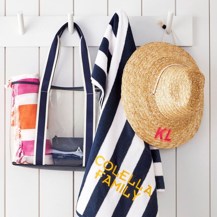 two beach towels and a straw hat hanging on the wall