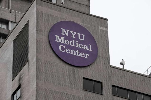 a purple sign on the side of a gray building that says nyu medical center