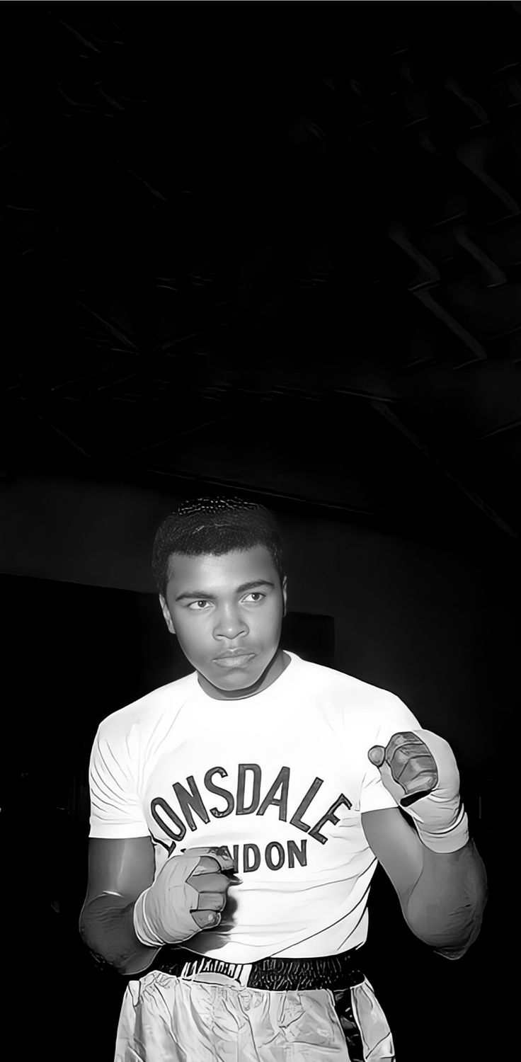 a black and white photo of a man wearing boxing gloves