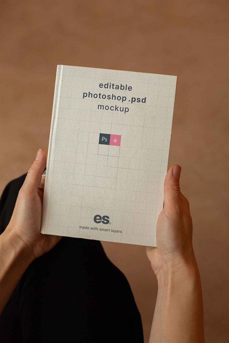 a person holding up a book with the title edible photoshop pad mockup on it