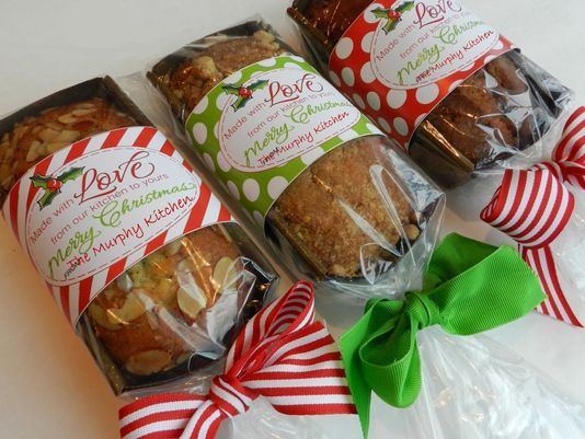 four packages of christmas treats are wrapped in cellophane and tied with green ribbon