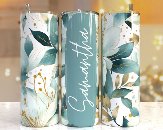 three personalized tumbles with floral designs on them, one is blue and the other has white flowers