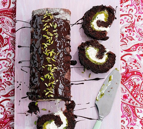 chocolate cake with white cream and sprinkles on it next to a knife