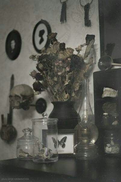 there is a vase with dead flowers in it on the table next to other items