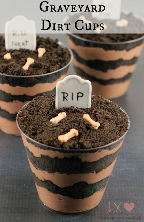 three graveyard dirt cups with tombstones in the middle and graves on each cupcake