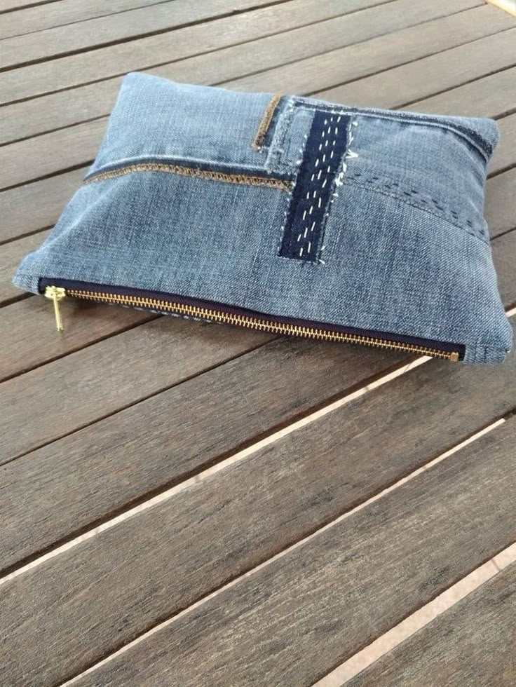 a denim zippered pouch sitting on top of a wooden table