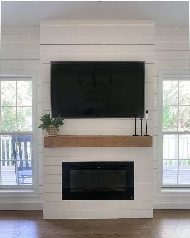 a flat screen tv mounted above a fireplace