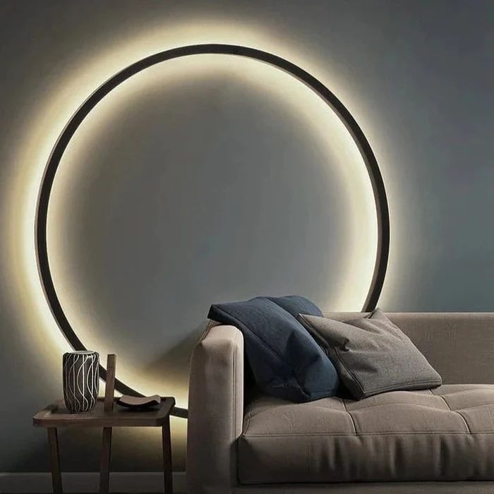 a living room with a couch and a round light on the wall