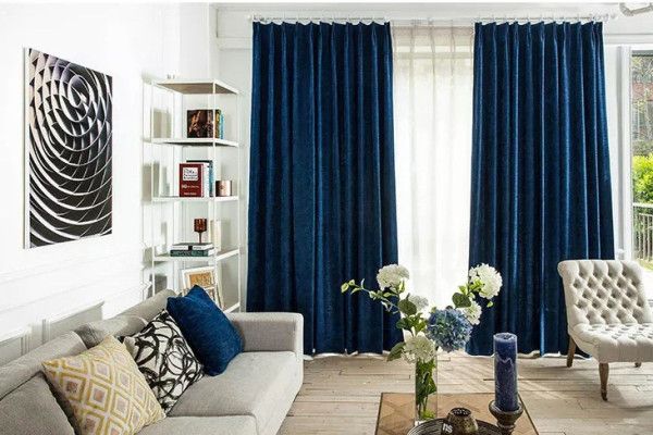 a living room filled with furniture and blue curtains