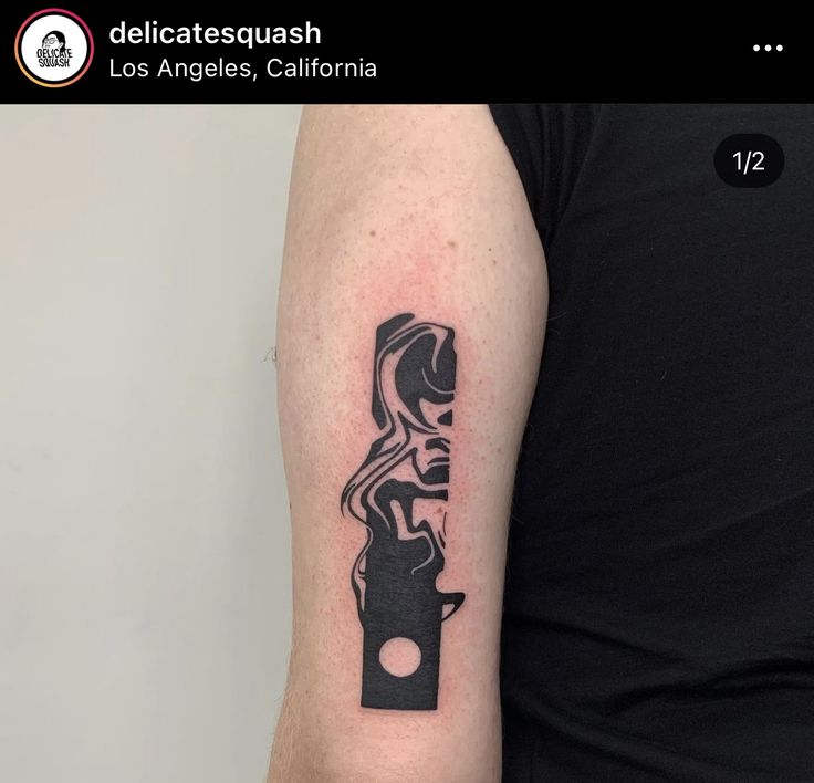 a man's arm with a black and white tattoo on it