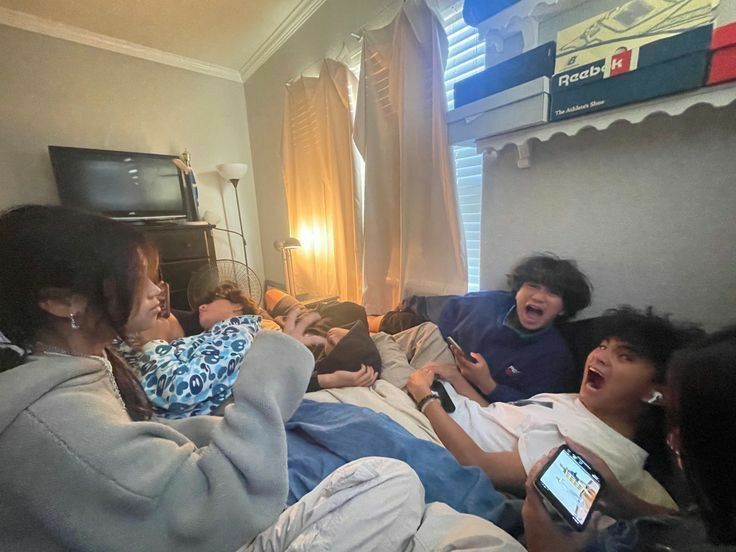 a group of people laying on top of a bed next to each other in a room