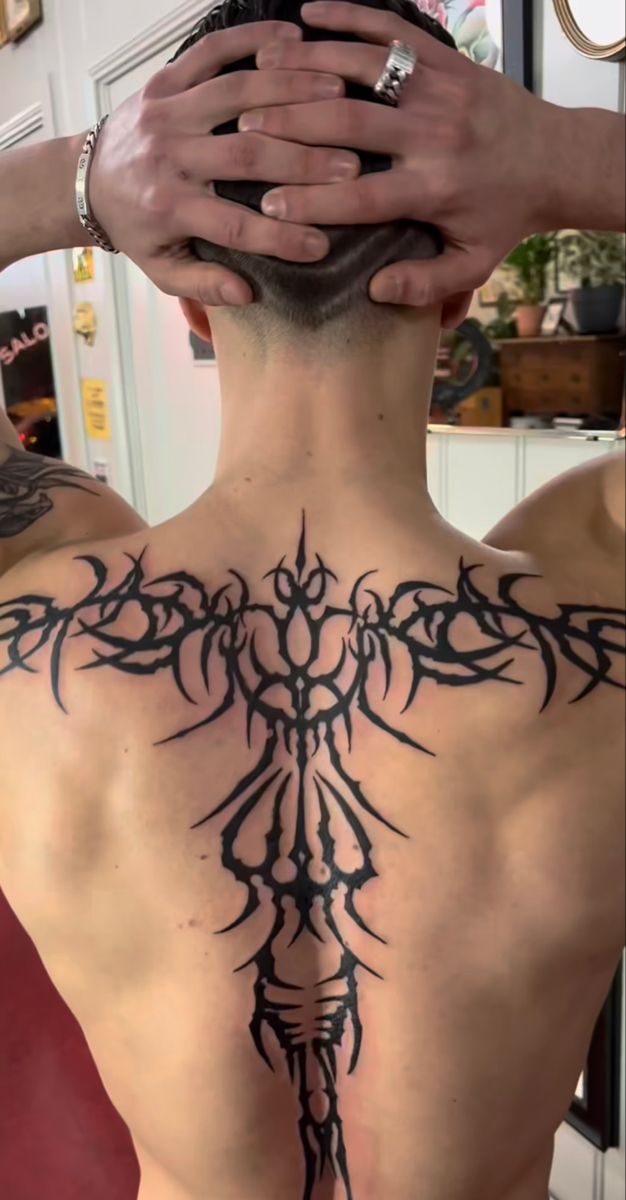 the back of a man with tattoos on his body