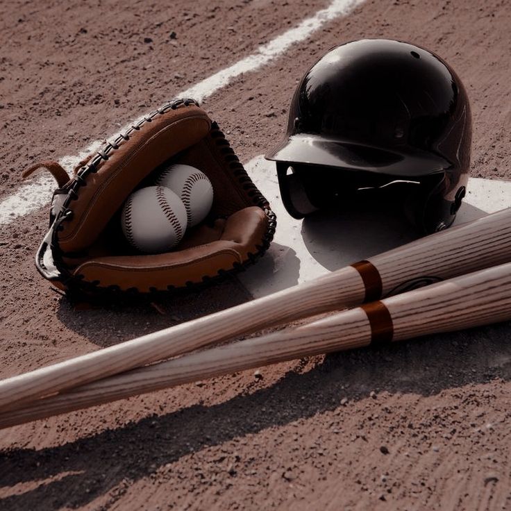 a baseball bat, helmet and glove sitting on the ground