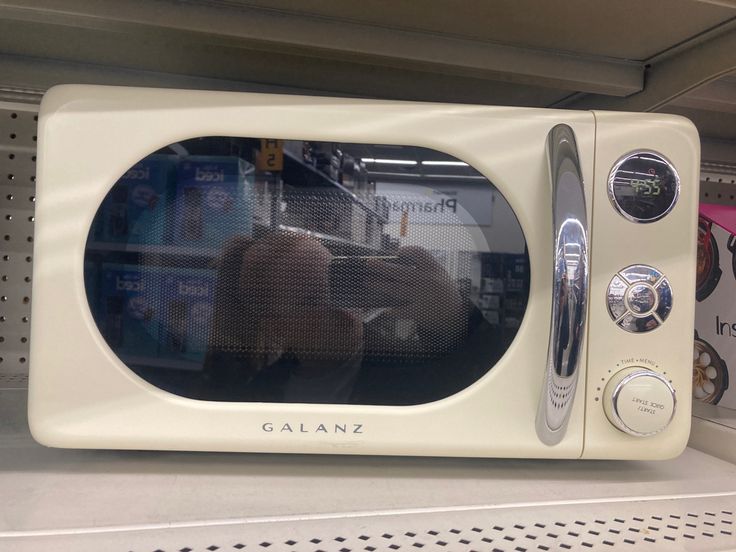 a white microwave oven sitting on top of a shelf